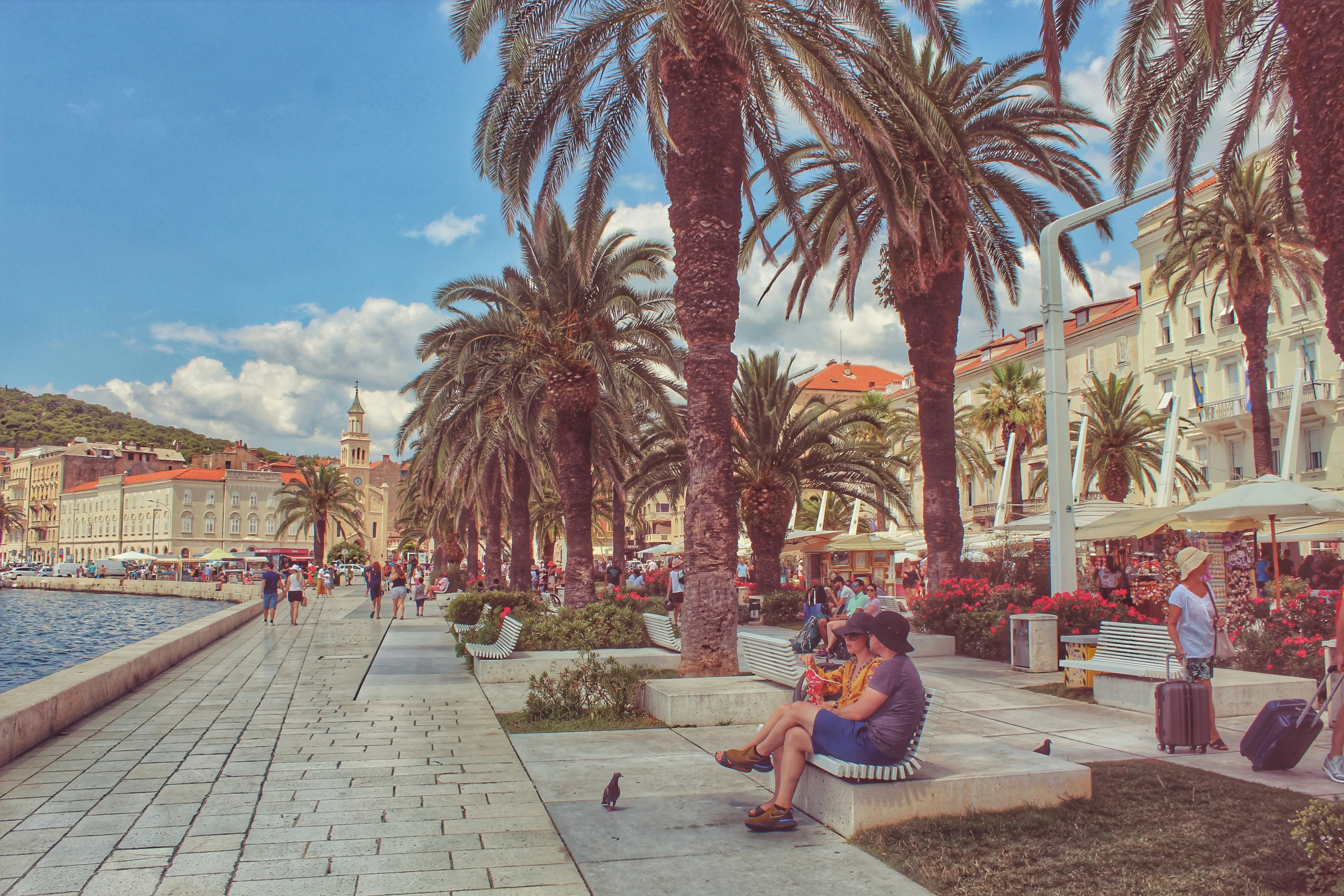 Personnes se détendant sur la promenade Riva à Split, Croatie, avec bâtiments historiques et vue sur la mer