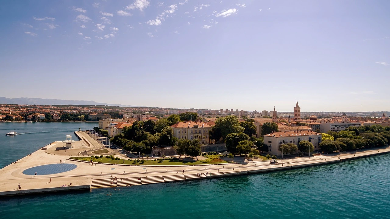 Panoramic view of Zadar, Croatia featuring the Sea Organ and monument to the sun on the waterfront, with the historic city and its distinctive Bell Tower stretching behind